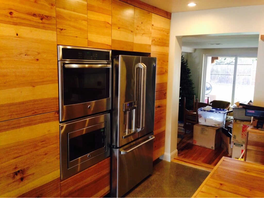 Cabinet finishing in Sacramento, CA by Baldwin Custom Painting — natural wood kitchen cabinets with stainless steel appliances