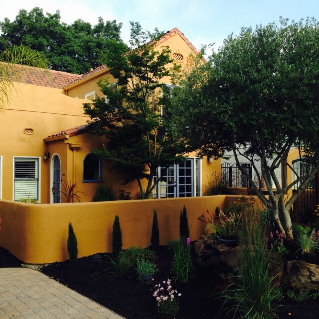 Exterior house painting in Sacramento, CA by Baldwin Custom Painting — yellow stucco home with brown tile roof