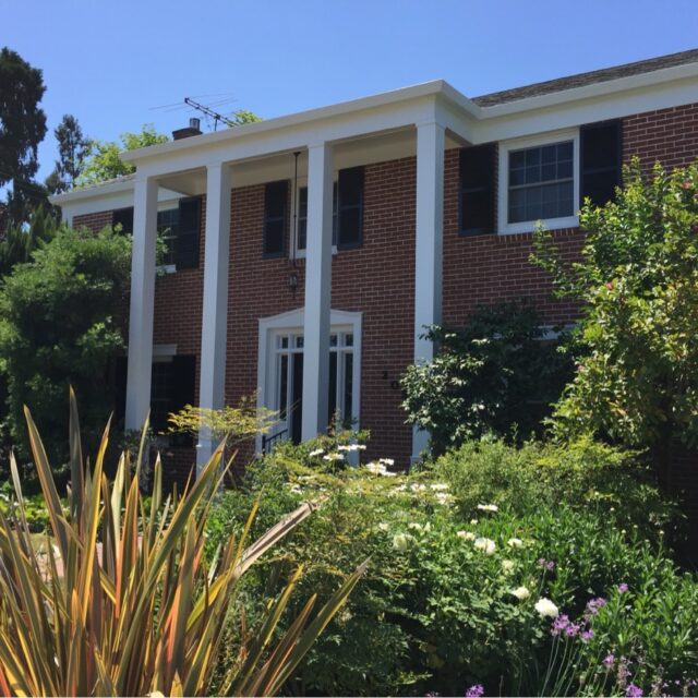 Exterior house painting in Sacramento, CA by Baldwin Custom Painting — brick two-story home with white columns