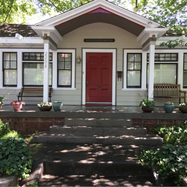 Exterior house painting in Sacramento, CA by Baldwin Custom Painting — gray home with red front door and front porch