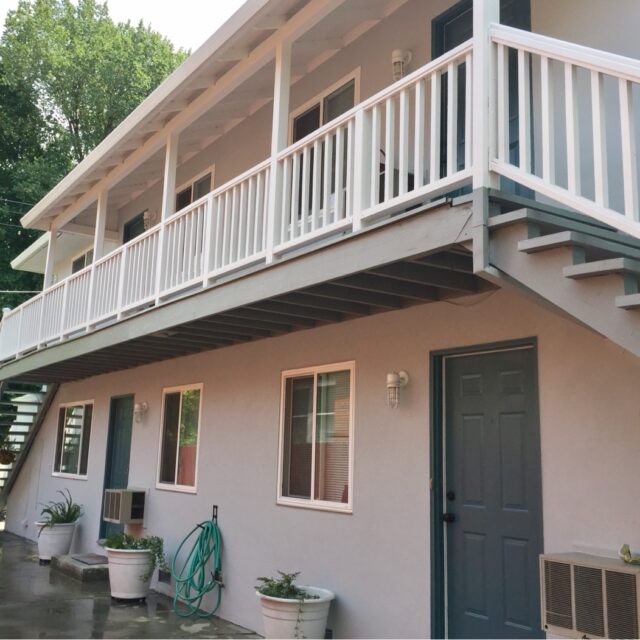 Exterior house painting in Sacramento, CA by Baldwin Custom Painting — gray bungalow with white trim and porch railing