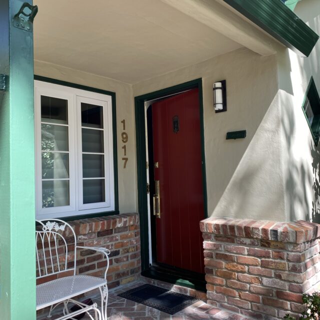 Exterior house painting in Sacramento, CA by Baldwin Custom Painting — white home with red front door and porch