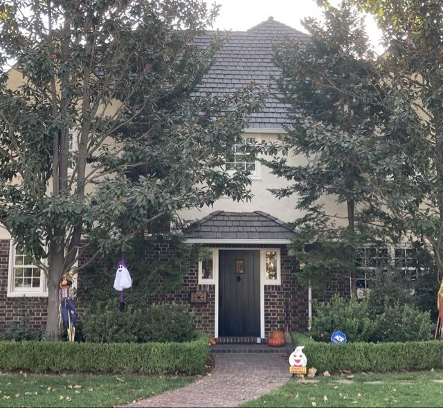 Exterior house painting in Sacramento, CA by Baldwin Custom Painting — house facade framed by mature trees