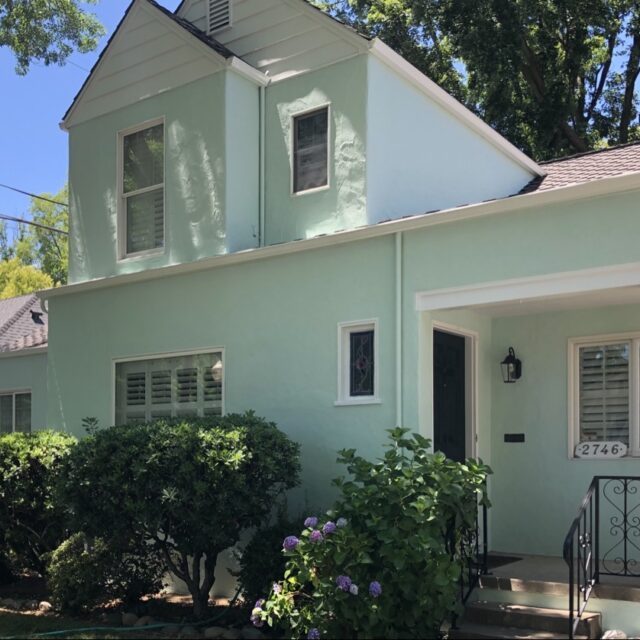 Exterior house painting in Sacramento, CA by Baldwin Custom Painting — light green two-story home with white trim
