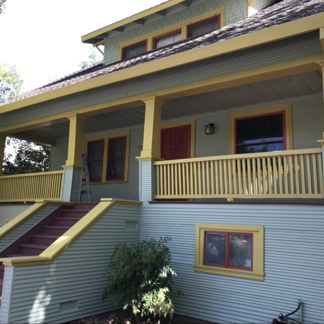 Exterior house painting in Sacramento, CA by Baldwin Custom Painting — Victorian two-story with yellow trim and wraparound porch