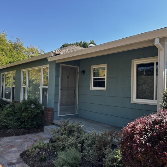 Exterior house painting in Sacramento, CA by Baldwin Custom Painting — blue-gray single-story home with white trim