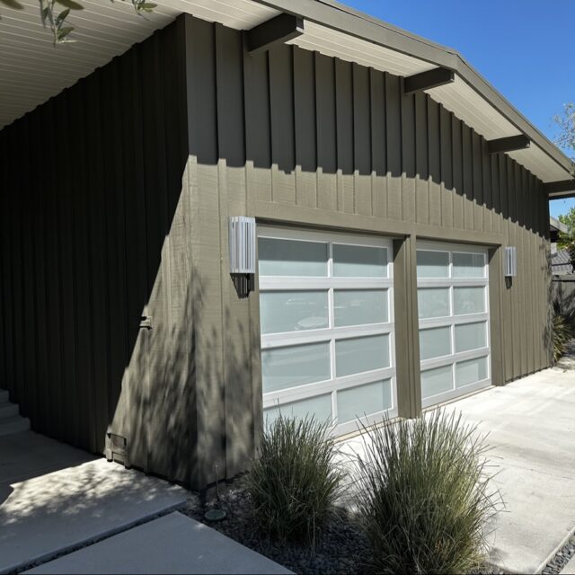 Exterior house painting in Sacramento, CA by Baldwin Custom Painting — modern home with gray siding and large garage door
