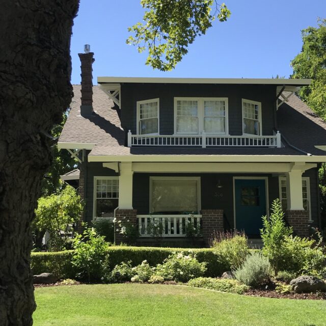 Exterior house painting in Sacramento, CA by Baldwin Custom Painting — two-story home with dark green siding and white trim