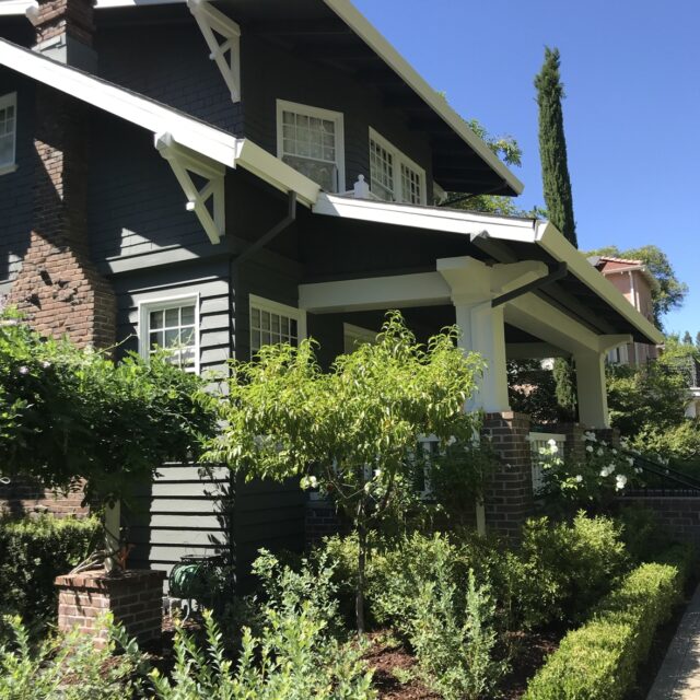 Exterior house painting in Sacramento, CA by Baldwin Custom Painting — dark brown two-story home with white trim