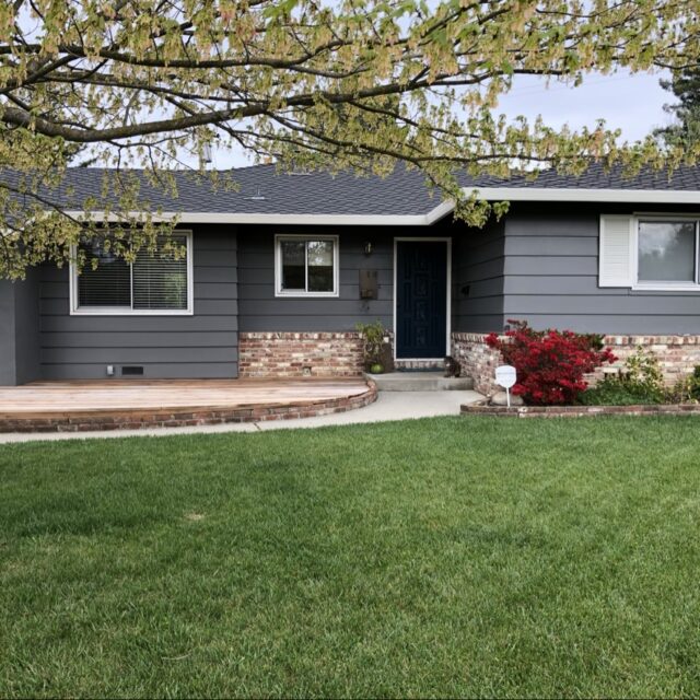 Exterior house painting in Sacramento, CA by Baldwin Custom Painting — gray ranch home with dark shutters and covered porch