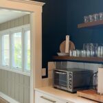 Dark green accent wall with white door trim