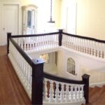 Entryway staircase with white balusters and dark wood handrail