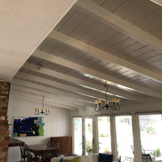 Interior house painting in Sacramento, CA by Baldwin Custom Painting — bright living room with white beamed ceiling